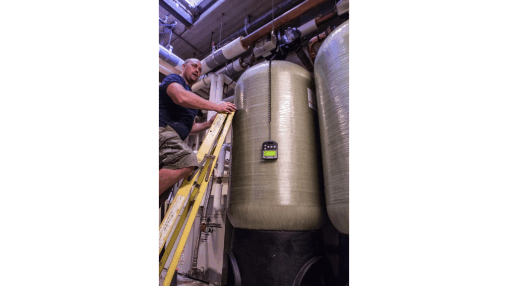 Technician climbing ladder on tank