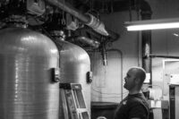 Man looking at commercial water tank